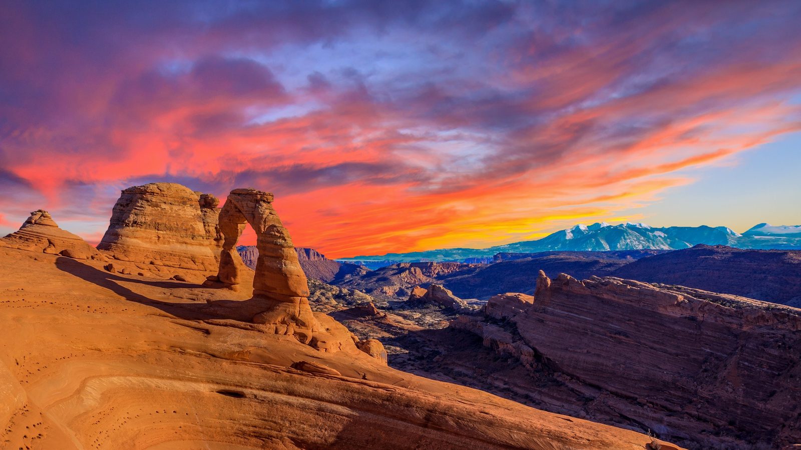 Delicate Arch beneath a fiery red-and-orange sunset sky, Arches National Park, Utah.