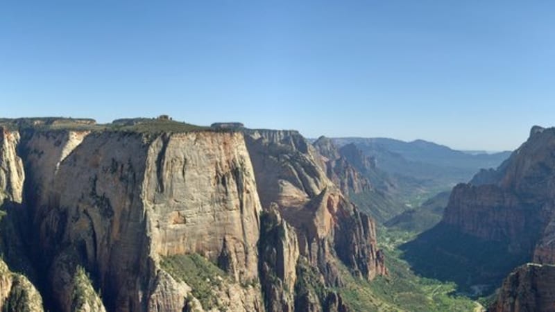 A sweeping aerial view of Zion Canyon with red sandstone cliffs flanking the Virgin River valley
